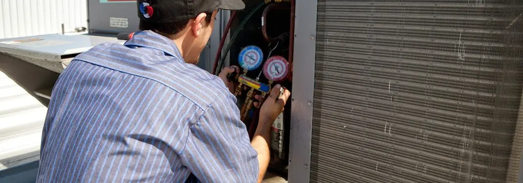 HVAC technician servicing a condenser unit in McKinleyville